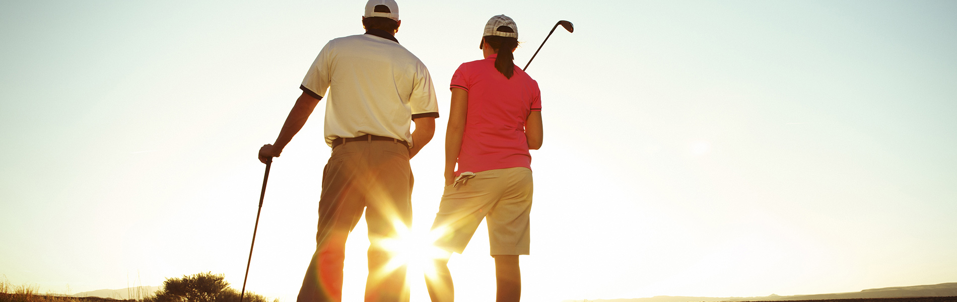 Man and Woman Playing Goft at Sunset